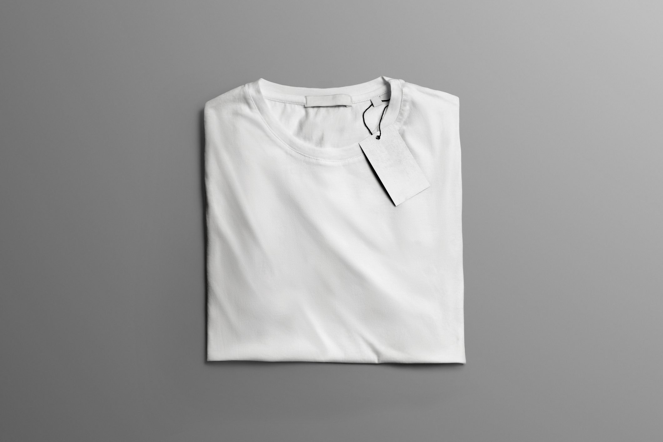 Свернутая футболка. Сложенная футболка. Белая футболка сложенная. Майка сложенная. Стопка белых футболок.
